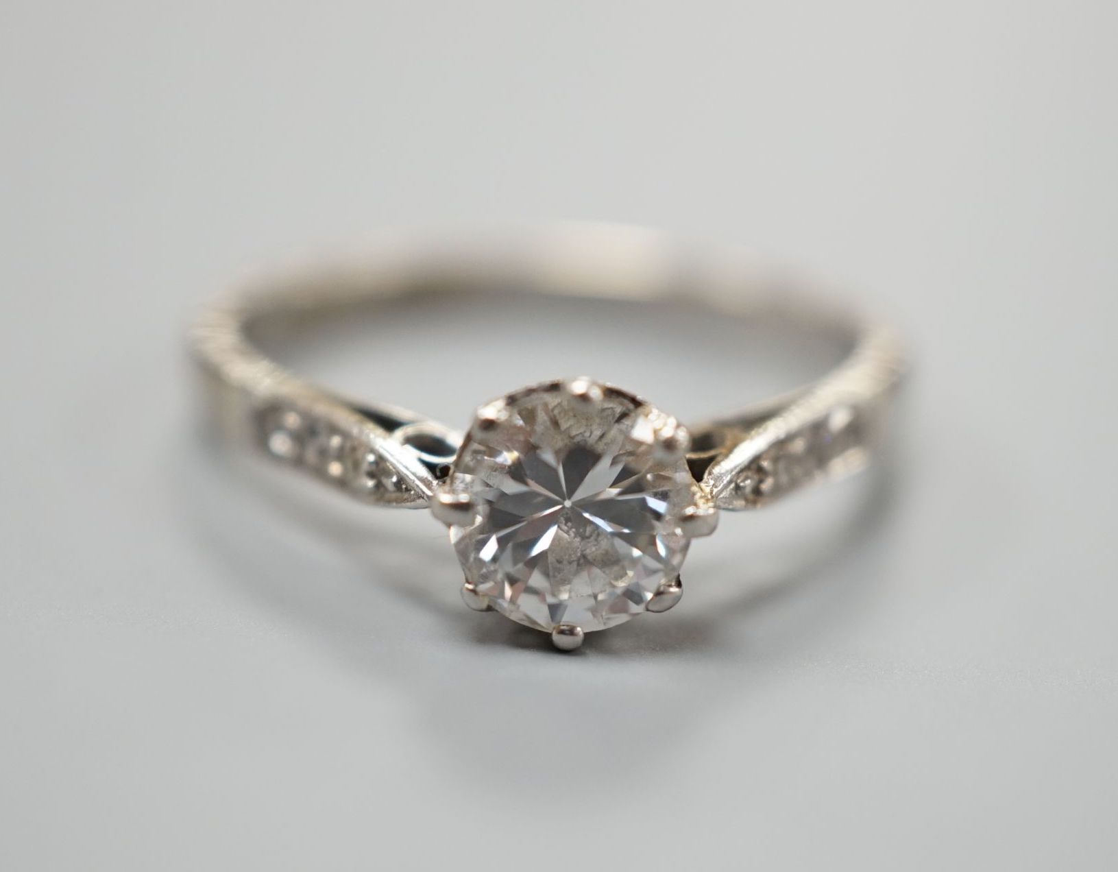 An 18ct and plat, single stone diamond ring, with diamond set shoulders, size O, gross weight 2.9 grams